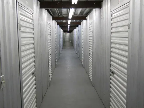 View of indoor storage units down a clean, well-lit hallway